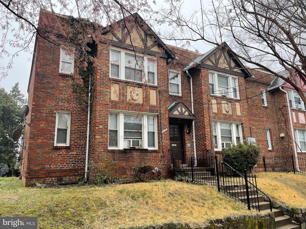 view of front of property with cooling unit and a front lawn