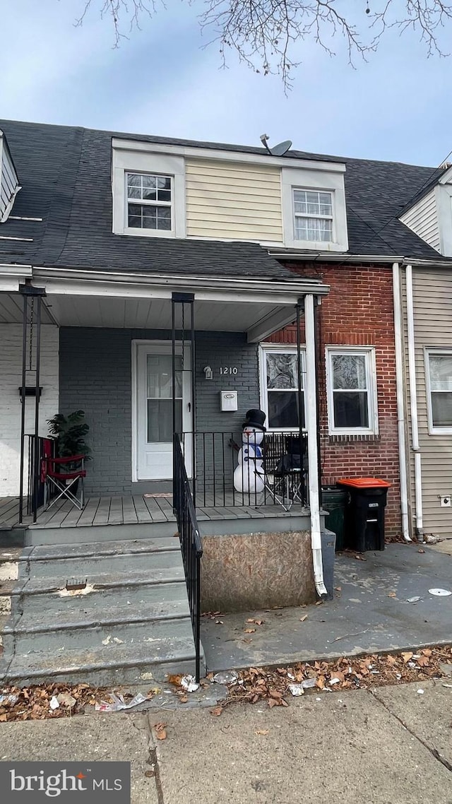 view of front of home with brick siding and covered porch