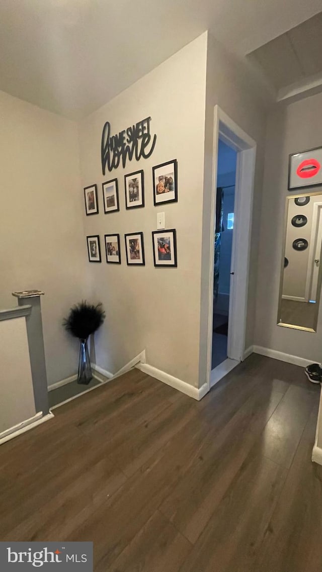 unfurnished dining area featuring baseboards and dark wood-style floors