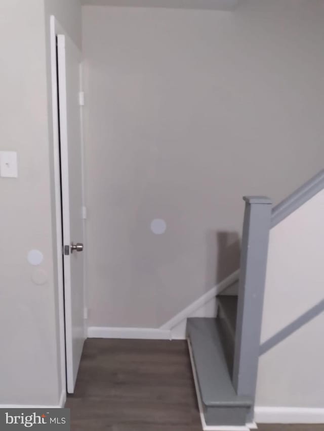 stairs featuring wood finished floors and baseboards