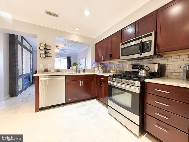 kitchen featuring decorative backsplash, appliances with stainless steel finishes, ceiling fan, crown molding, and sink