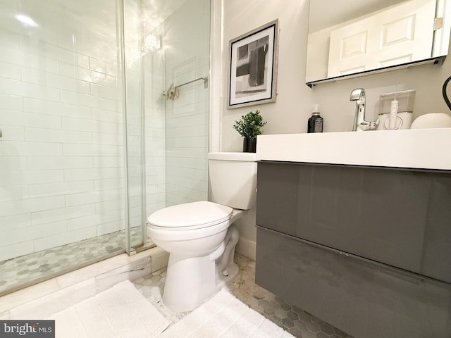 bathroom with tile patterned floors, vanity, toilet, and walk in shower