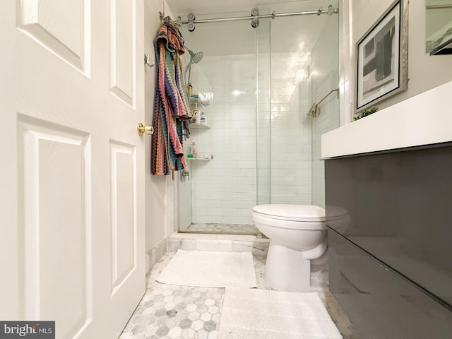 bathroom featuring toilet and a shower with shower door