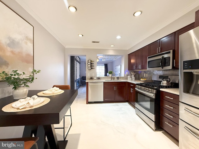 kitchen with sink, backsplash, kitchen peninsula, crown molding, and appliances with stainless steel finishes