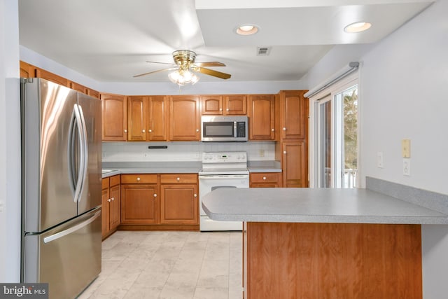 kitchen featuring ceiling fan, backsplash, kitchen peninsula, and appliances with stainless steel finishes