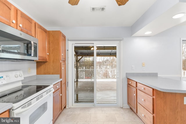 kitchen featuring white range with electric stovetop, backsplash, and ceiling fan