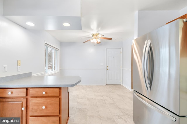 kitchen featuring ceiling fan, kitchen peninsula, and stainless steel refrigerator