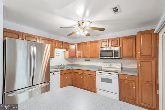 kitchen featuring ceiling fan, stainless steel appliances, tasteful backsplash, and sink