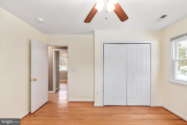 unfurnished bedroom featuring light wood-type flooring, ceiling fan, and a closet