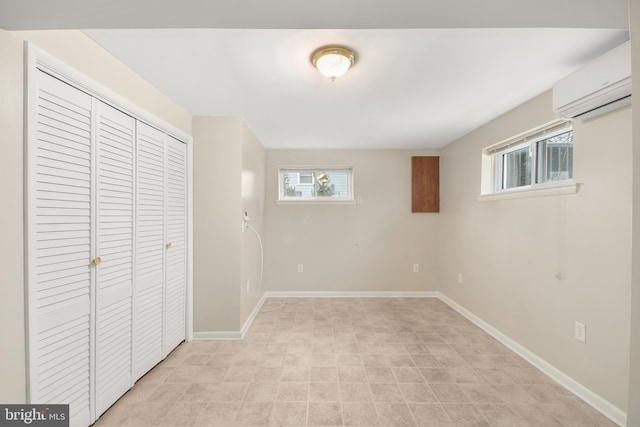 unfurnished bedroom featuring multiple windows, a closet, and a wall mounted air conditioner