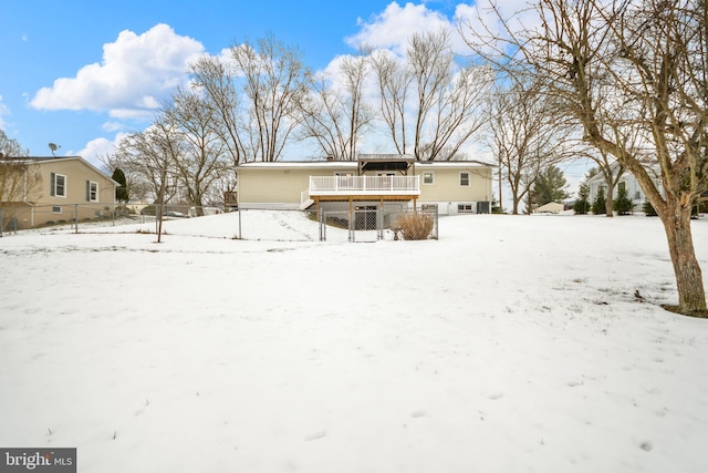 snow covered back of property featuring a wooden deck