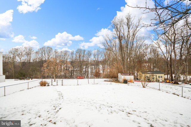 yard covered in snow with an outbuilding