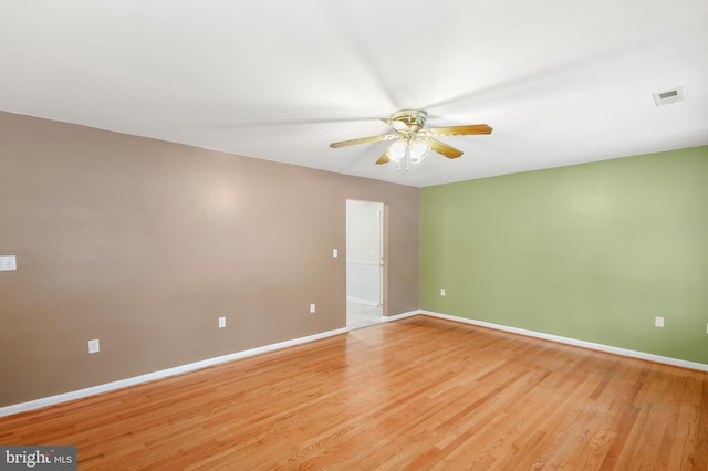 empty room with ceiling fan and light hardwood / wood-style flooring