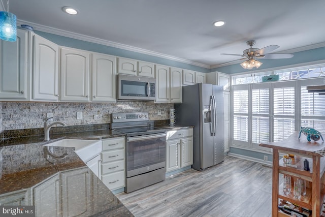 kitchen featuring white cabinets, ceiling fan, dark stone countertops, appliances with stainless steel finishes, and light hardwood / wood-style floors