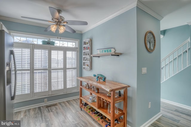 dining space featuring light hardwood / wood-style flooring, ceiling fan, and crown molding