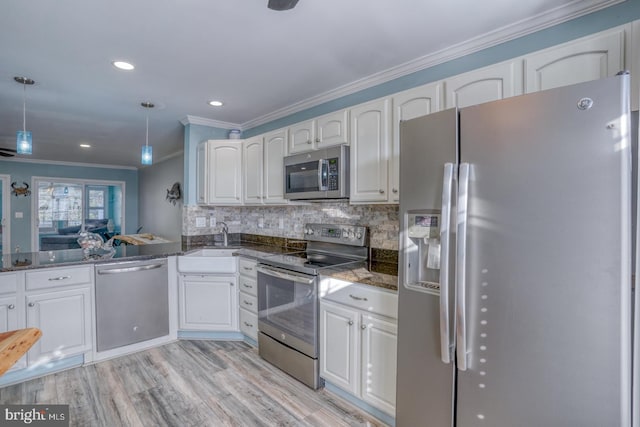 kitchen featuring sink, light hardwood / wood-style floors, pendant lighting, white cabinets, and appliances with stainless steel finishes