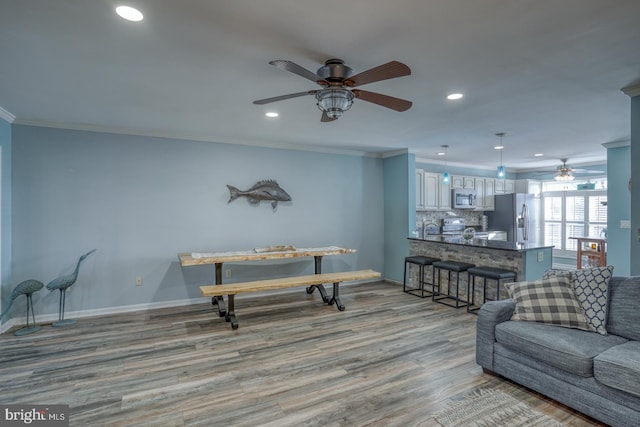 living room with light wood-type flooring and ornamental molding