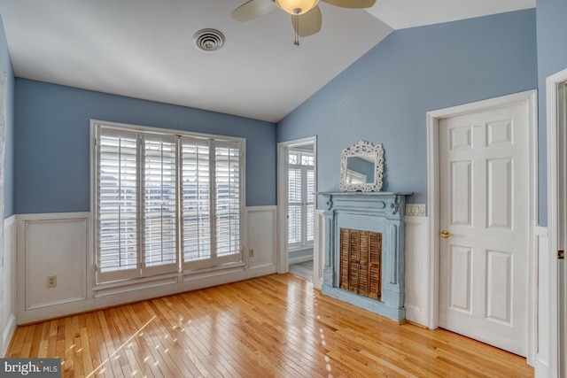 unfurnished living room with ceiling fan, wood-type flooring, and lofted ceiling