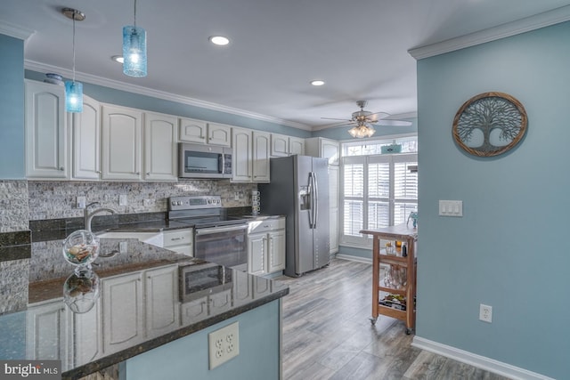 kitchen with kitchen peninsula, decorative backsplash, dark stone counters, stainless steel appliances, and decorative light fixtures