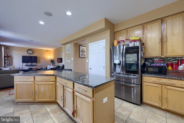 kitchen with tasteful backsplash, stainless steel fridge with ice dispenser, light brown cabinets, and dark stone counters