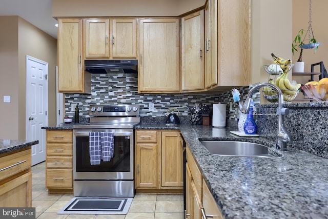 kitchen with stainless steel range with electric stovetop, decorative backsplash, sink, and dark stone counters