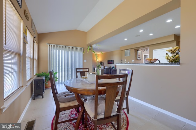 tiled dining room featuring vaulted ceiling