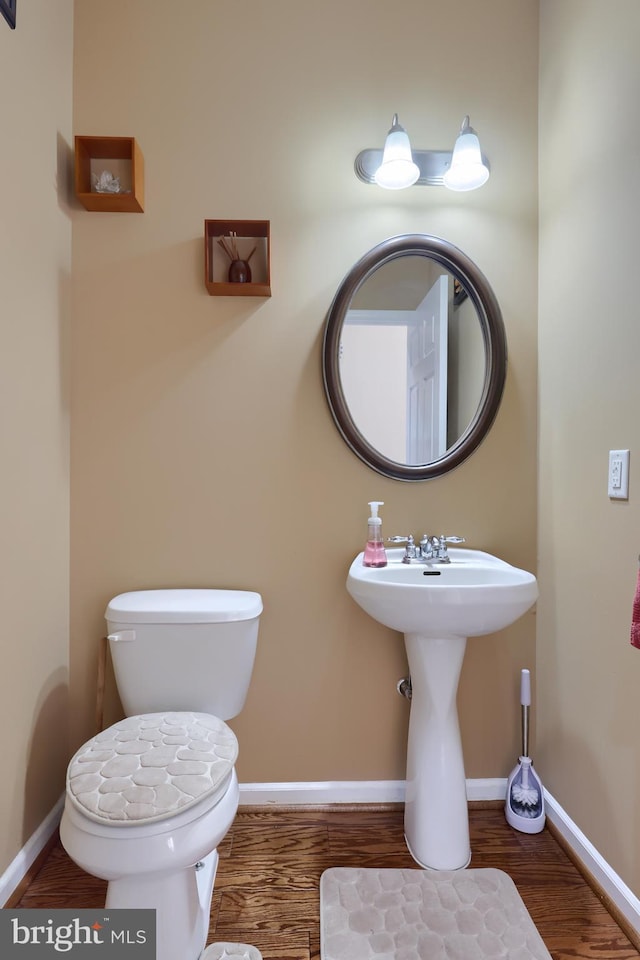 bathroom with toilet and wood-type flooring