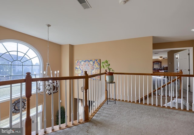 hall with a chandelier and carpet