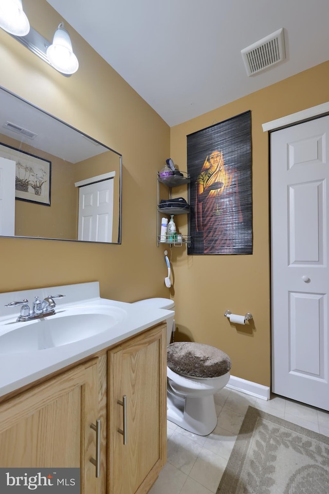 bathroom featuring tile patterned flooring, vanity, and toilet