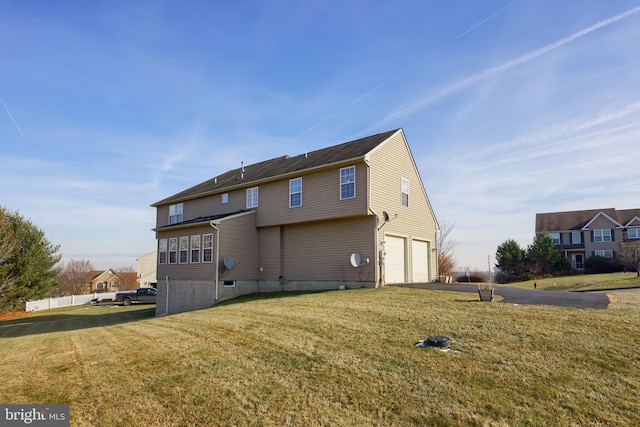 rear view of house with a yard and a garage