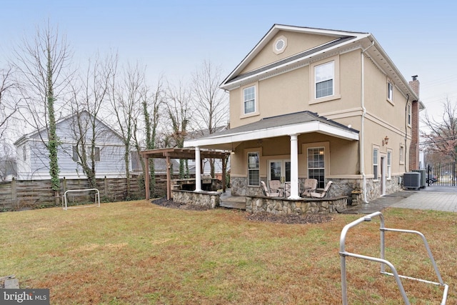 rear view of house with a patio, central AC, and a lawn