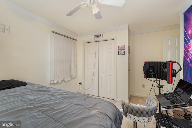 bedroom with carpet, ceiling fan, ornamental molding, and a closet