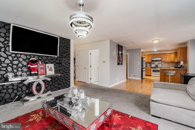 living room with a chandelier and light hardwood / wood-style flooring