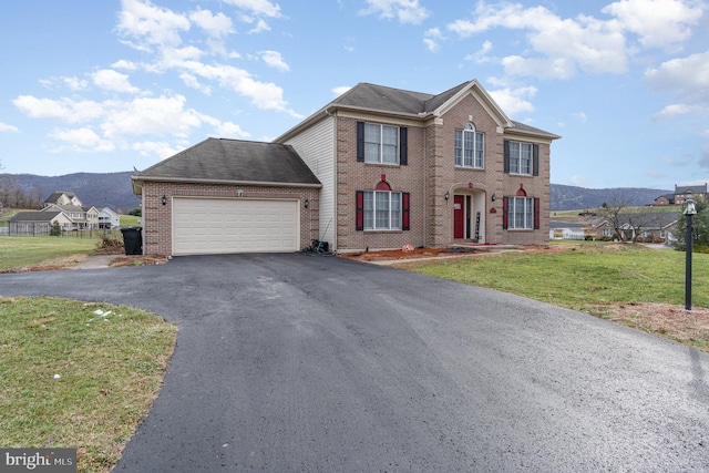 view of front of home featuring a front yard, a mountain view, and a garage