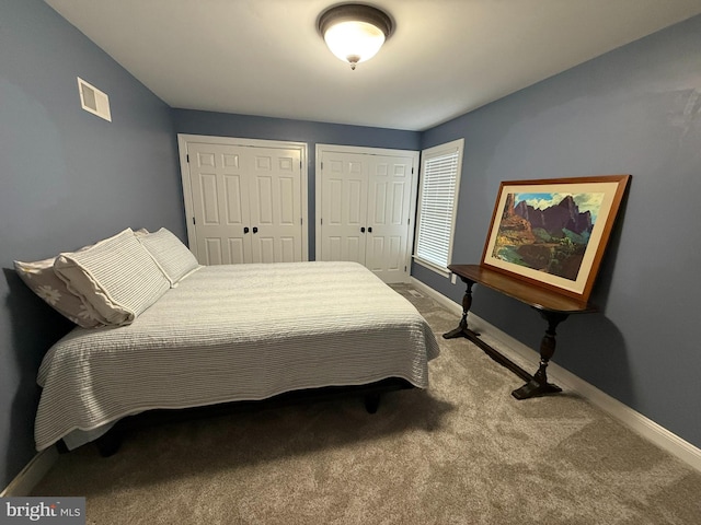 bedroom with carpet flooring and multiple closets