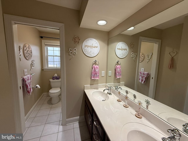 bathroom with tile patterned flooring, vanity, and toilet