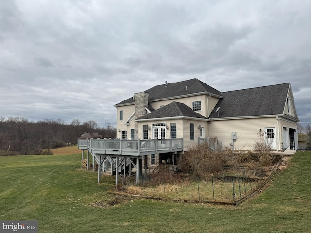 back of property featuring a deck and a yard