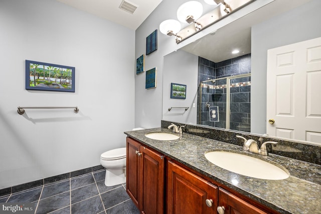 bathroom featuring tile patterned flooring, vanity, toilet, and a shower with shower door