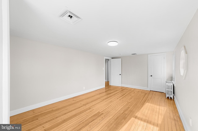 unfurnished bedroom featuring light hardwood / wood-style floors and radiator