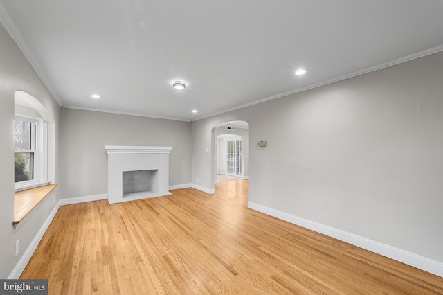 unfurnished living room with ornamental molding and light wood-type flooring