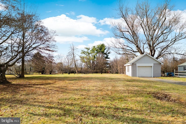 view of yard featuring a garage and an outbuilding