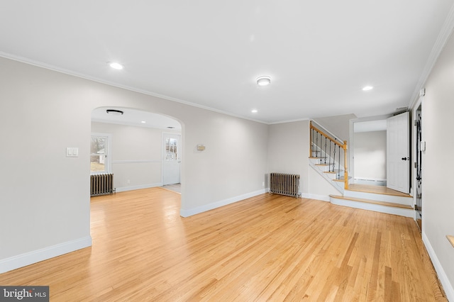 unfurnished living room with light wood-type flooring, radiator heating unit, and ornamental molding