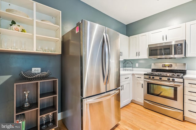 kitchen featuring white cabinets, light wood-type flooring, and stainless steel appliances