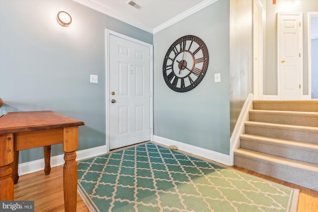 entrance foyer with hardwood / wood-style floors and crown molding