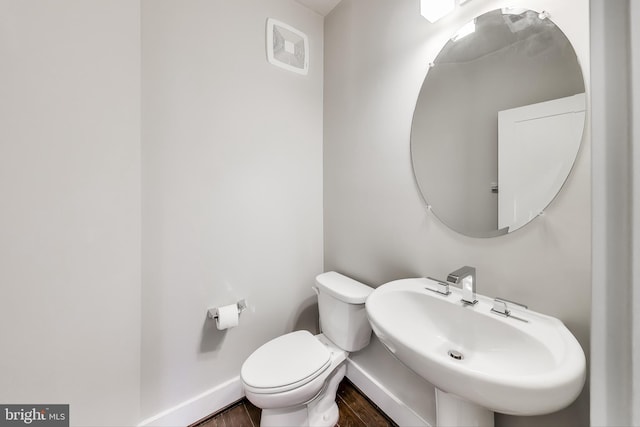 bathroom with hardwood / wood-style floors, toilet, and sink