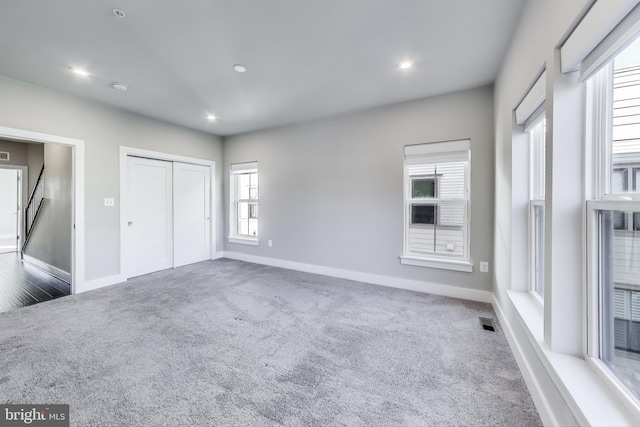 unfurnished bedroom featuring a closet and dark carpet