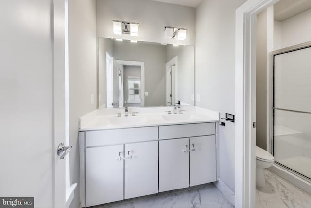 bathroom with a shower with door, vanity, and toilet