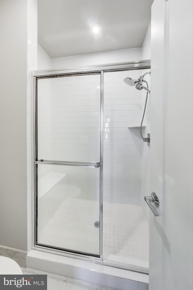 bathroom with a shower with door