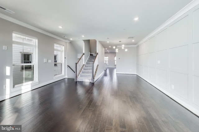 unfurnished living room featuring dark hardwood / wood-style floors and ornamental molding