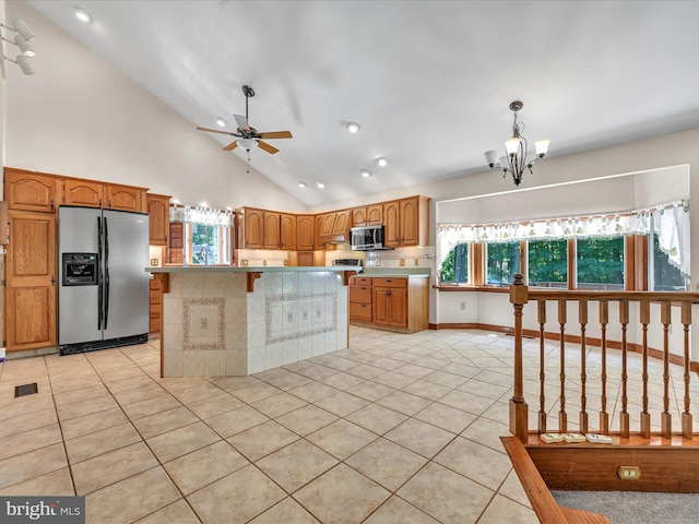 kitchen with plenty of natural light, a kitchen island, hanging light fixtures, and appliances with stainless steel finishes